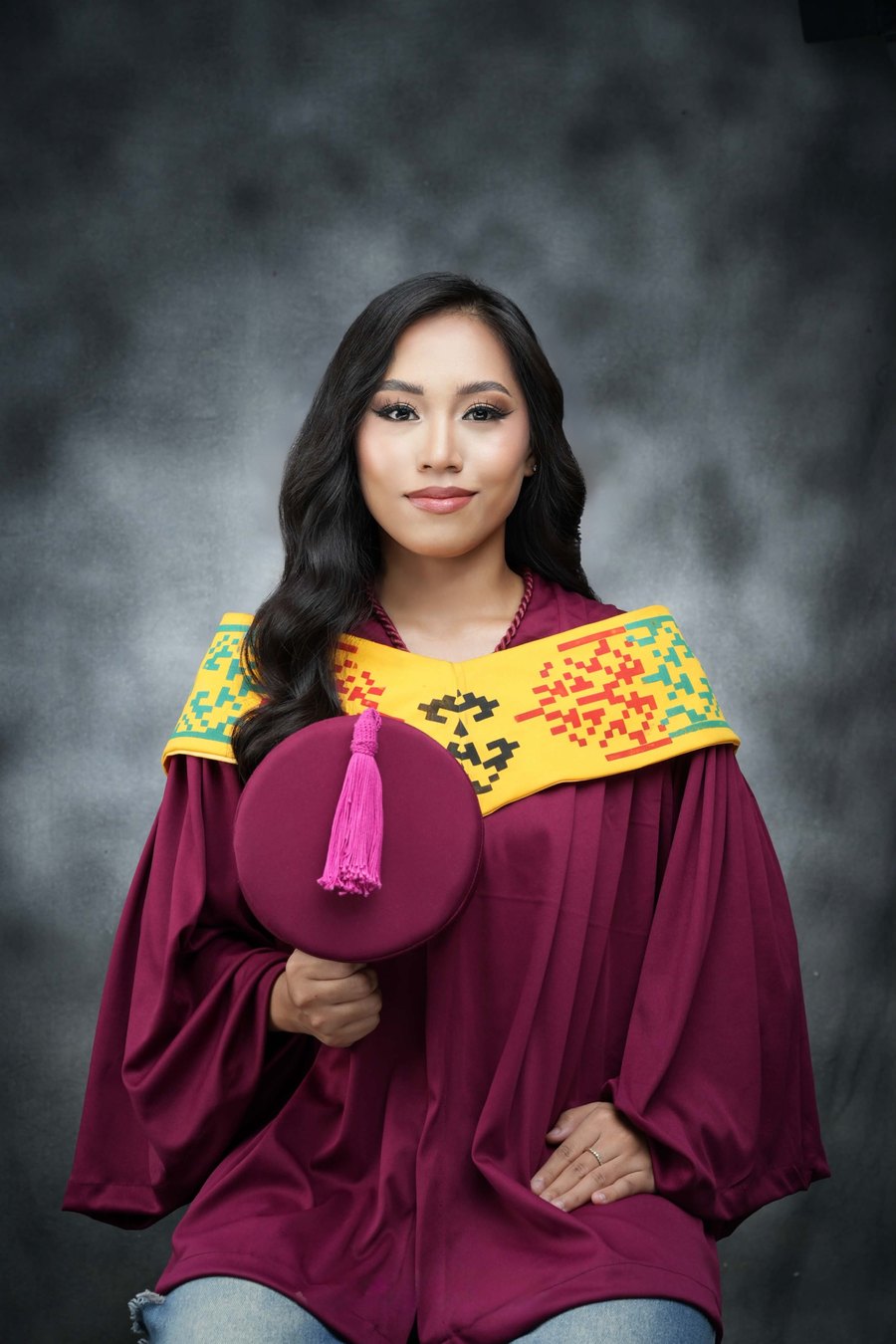 Khaila Gavino in her graduation toga, holding her cap